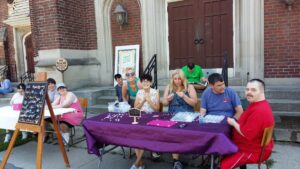 A group of staff and Pegasus participants at a table selling jewelry.