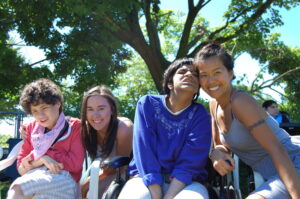 Two staff and two participants smiling in front of trees.