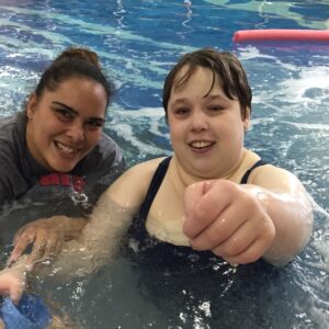 A participant and an instructor in a swimming pool.