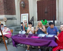 A group of staff and Pegasus participants at a table selling jewelry.